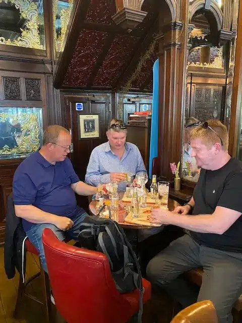 A group of men sitting at a table enjoying Gin samples during a Real London Walk bespoke Gin tour.