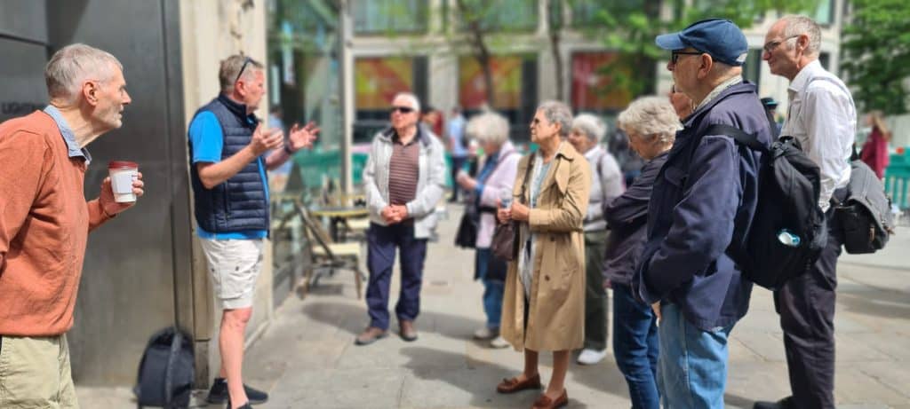 Tour guide Clive Lotherington explains the secrets of London to a tour group on a London street.